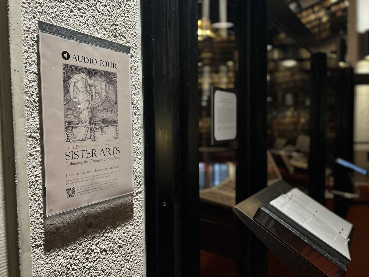 Photo of the entrance to the Fisher Library displaying the poster for the Sister Arts exhibit