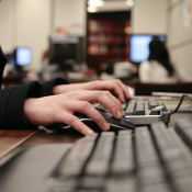 two hands type on a black keyboard. 